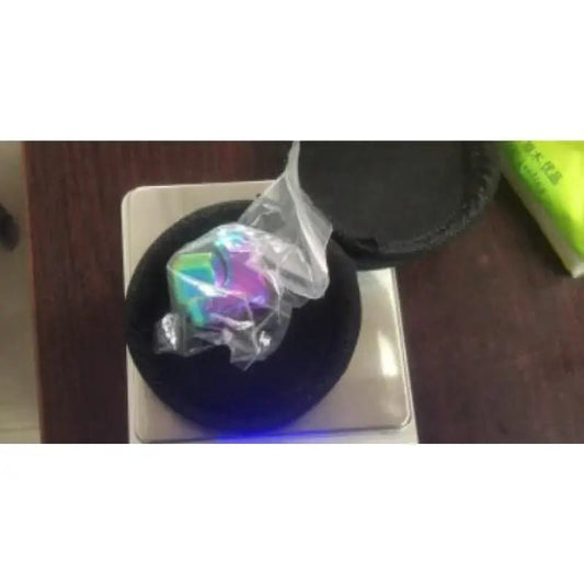Colorful crystal ball in a black container on a white surface with a blurred background