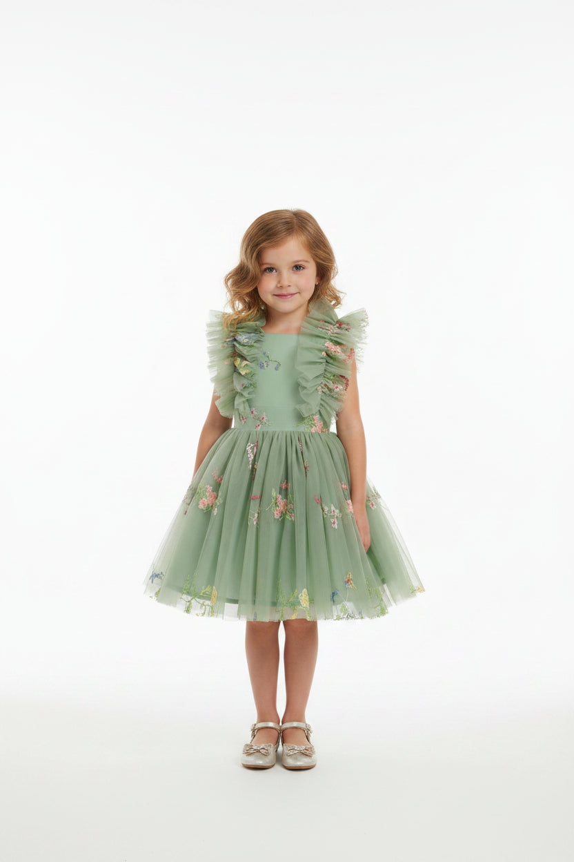 Green dress with floral embroidery and ruffled sleeves on a model with a white background