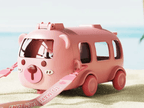 Pink toy bus with a sand shovel on a beach