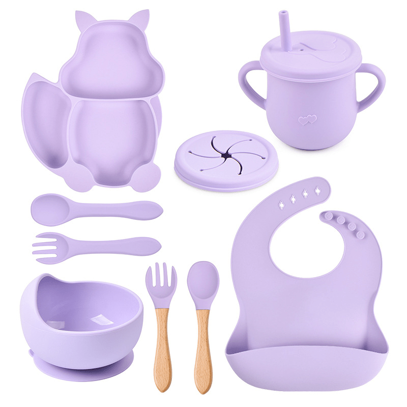 Purple baby feeding and dining set including cup, bowl, spoon, and bib on a white background