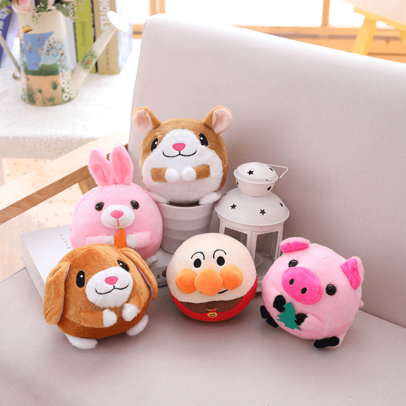 Set of five cartoon animal plush toys on a light-colored surface.