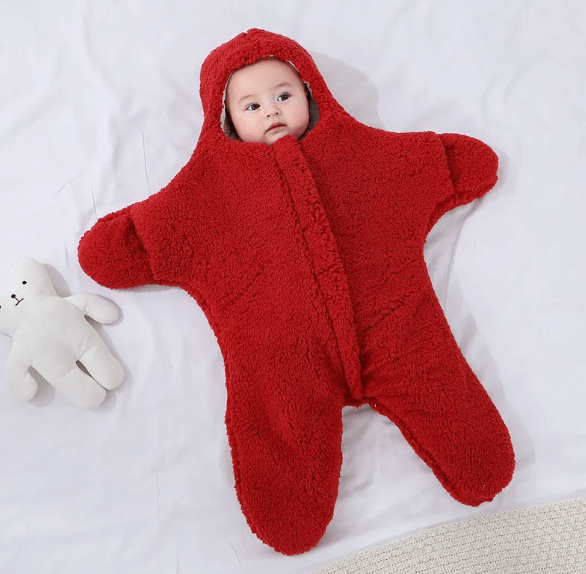 Baby wearing a red star-shaped onesie on a white background