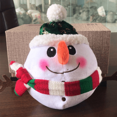 Plush snowman toy with a scarf on a wooden surface