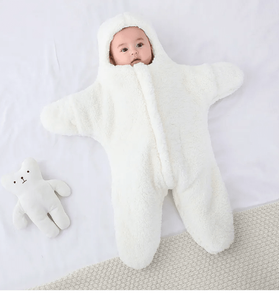 Baby in a white bear costume on a light gray background