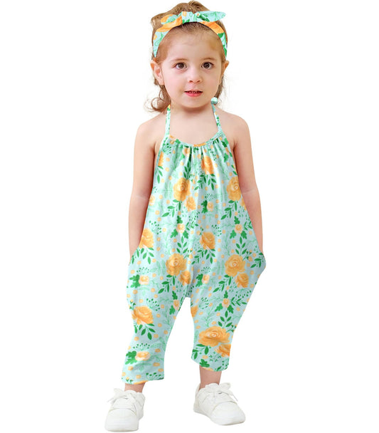 Child wearing a floral harem romper on a white background
