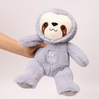 Plush toy sloth with a hand holding it against a light background