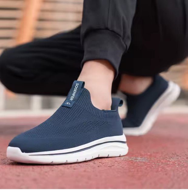 Person wearing navy slip-on shoes with white soles on a blurred background