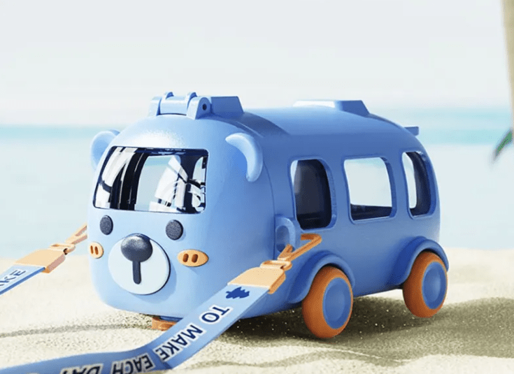 Toy bus with a character face on a sandy background
