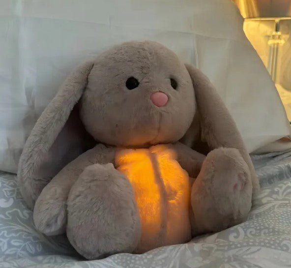 Plush bunny toy with glowing belly on a bed